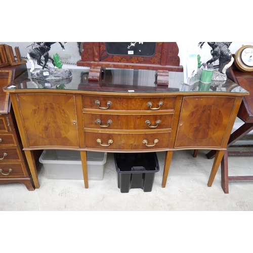 2098 - A reproduction Regency yew wood sideboard with three central drawers flanked by cupboards, raised on... 