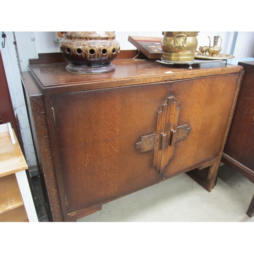 2445 - An Art Deco oak cupboard, two doors opening to reveal a shelved interior