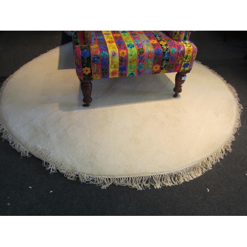 1555 - A cream ground circular rug with tassels, 190cm diameter