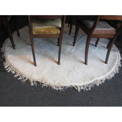 1556 - A cream ground circular rug with tassels, 190cm diameter