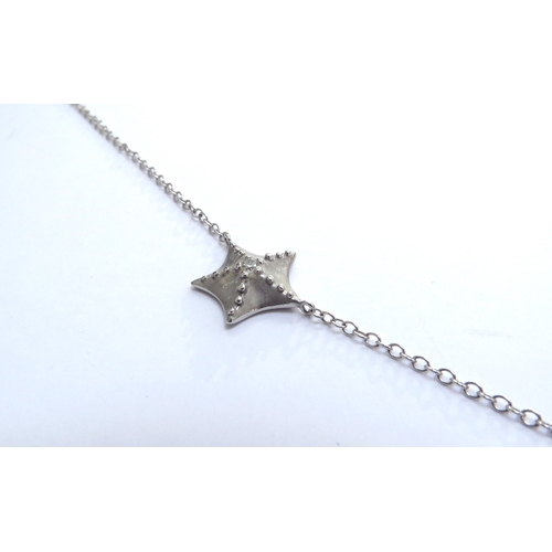 7401 - A Tiffany and Co white gold necklace interspersed with two starfish centrally set with a single diam... 