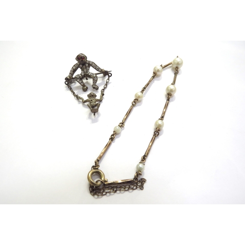 7394 - A pearl and gold bracelet, unmarked, 18cm long and a paste set brooch as a monkey with its baby on a... 