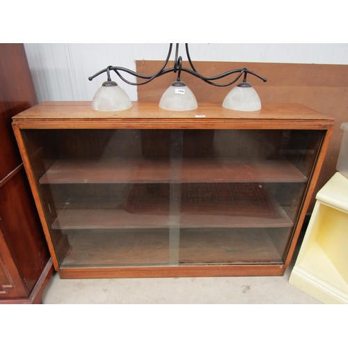 2407 - An oak half-height bookcase with sliding glass doors       (E) £5-10