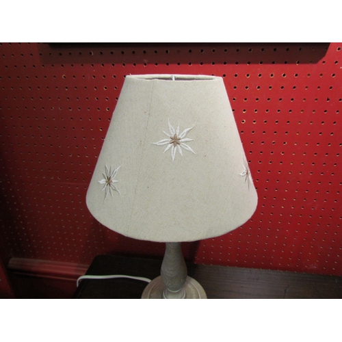 4044 - A white washed wooden table lamp together with a cream shade with edelweiss design