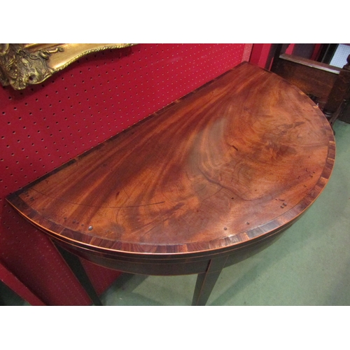 4074 - A George III crossbanded flame mahogany demi-lune games table with satinwood line inlay, the fold ov... 