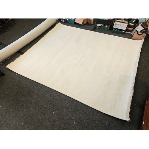 1402 - An Indian hand-knotted cream wool rug with tasselled ends, 320cm x 274cm