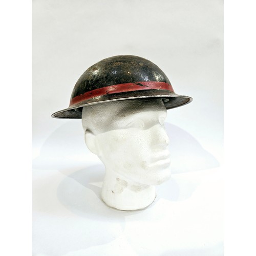 8103 - A WWII British Home Front steel helmet, black with stencilled indistinct lettering in white PFR / PE... 