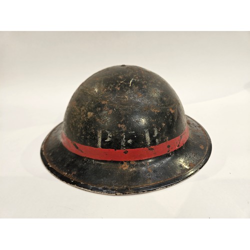 8103 - A WWII British Home Front steel helmet, black with stencilled indistinct lettering in white PFR / PE... 