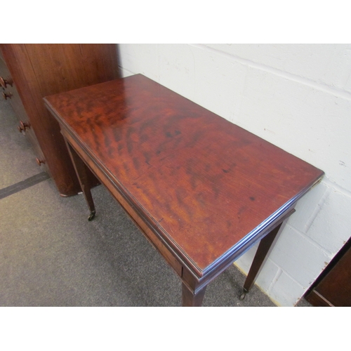 1023 - A 19th Century mahogany tea table, fold-over top, on square tapering legs to castors