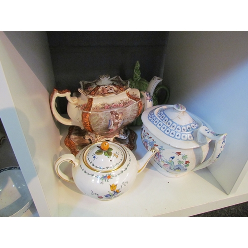 1216 - Ten teapots to include Victorian example on stand, crinoline lady, etc