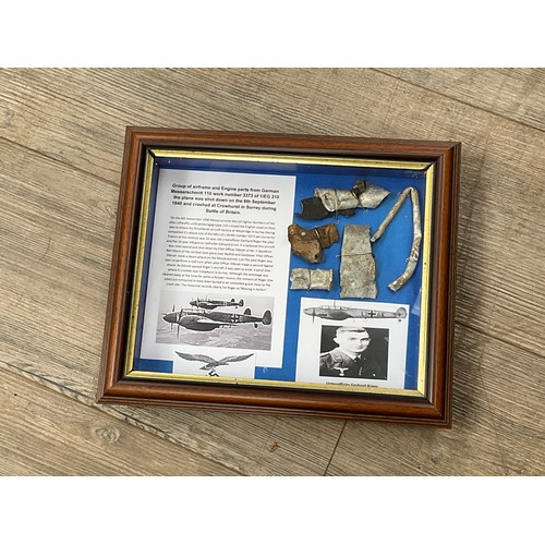 8566 - A collection of WWII Messerschmitt 110 aircraft crash relics, displayed within a glazed frame with c... 