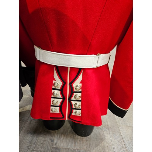 8196 - A half mannequin dressed in Irish Guards uniform together with boots and a great coat