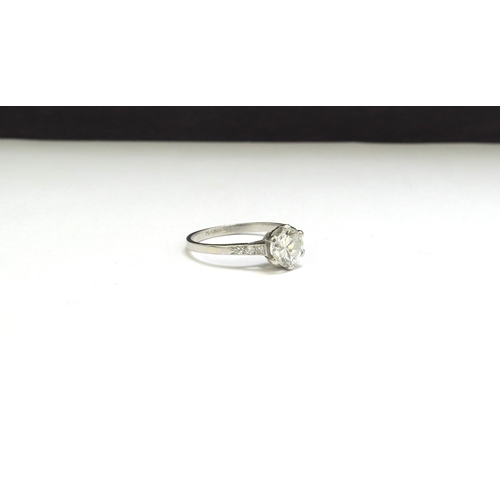 9012 - A platinum set diamond solitaire ring, 1ct approx flanked by diamond set shoulders. Size N, 2.3g