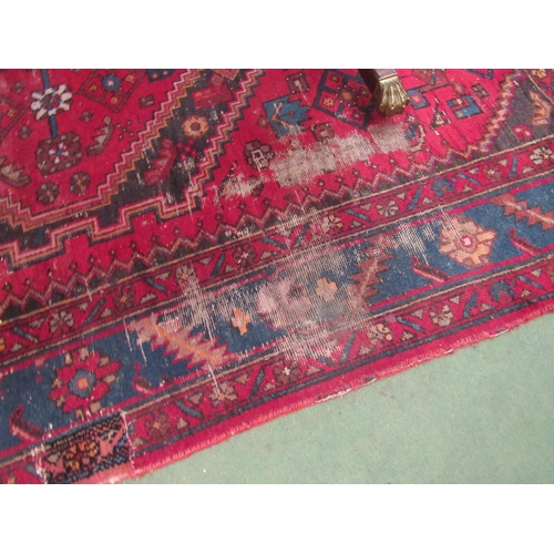 4482 - A Persian Hamadan rug, red ground with geometric and animal design, worn and repaired, 205cm x 134cm