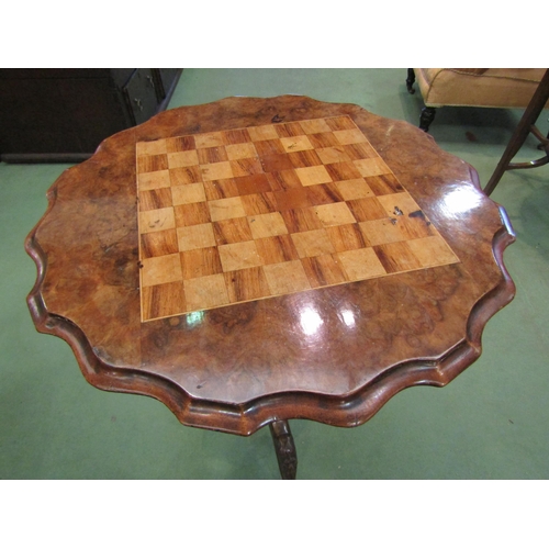 4076 - A late Victorian flame walnut games table, the chequerboard top with piecrust edge, reeded support, ... 