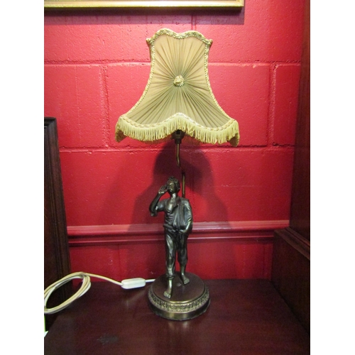 4114 - A brass and spelter table lamp of figural form, newspaper boy, with a green pleated shade, 62cm tall... 