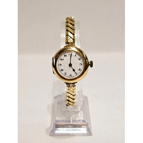 8179 - A 9ct gold cased wristwatch with white enamelled dial, Arabic numerals. Crack to enamel.  (R)  £70  ... 