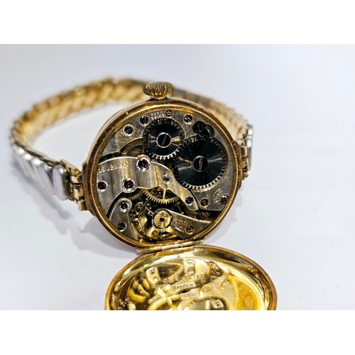 8179 - A 9ct gold cased wristwatch with white enamelled dial, Arabic numerals. Crack to enamel.  (R)  £70  ... 