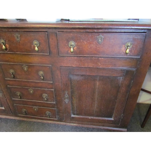 1015 - An oak dresser in the early 18th Century style with boarded plate rack above three drawer and two cu... 