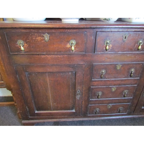 1015 - An oak dresser in the early 18th Century style with boarded plate rack above three drawer and two cu... 