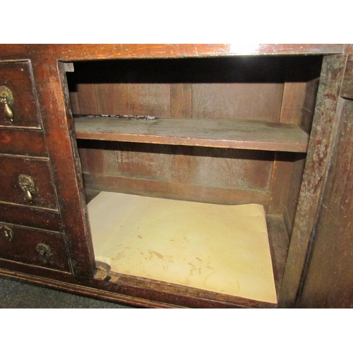 1015 - An oak dresser in the early 18th Century style with boarded plate rack above three drawer and two cu... 