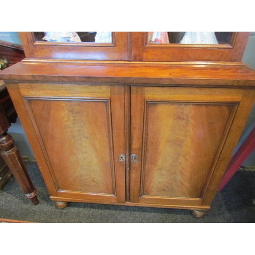 1052 - A 19th Century mahogany bookcase, glazed top with shelved interior over two cupboard door base, on b... 