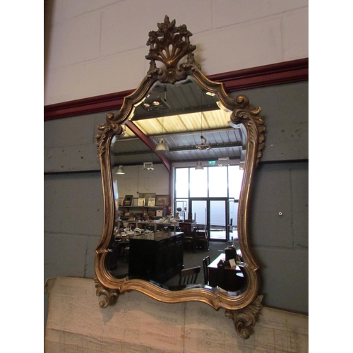 1062 - A reproduction Italian classical gilt wall mirror with floral crest and scrolled foliate mounts, 92c... 