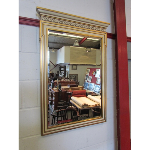 1071 - A gilt and cream painted wall mirror, the top with row of roundels, 104cm x 73cm