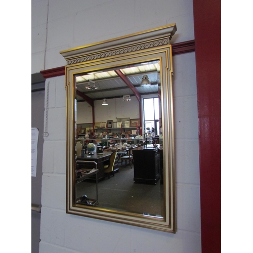 1071 - A gilt and cream painted wall mirror, the top with row of roundels, 104cm x 73cm