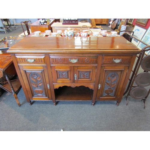 1107 - An Edwardian mahogany carved sideboard, three drawers above three cupboards with carved floral doors... 