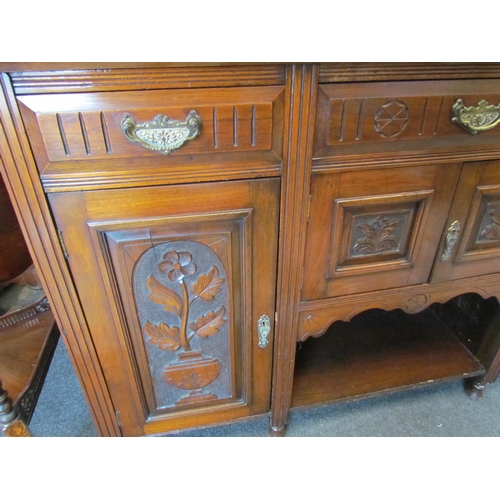 1107 - An Edwardian mahogany carved sideboard, three drawers above three cupboards with carved floral doors... 