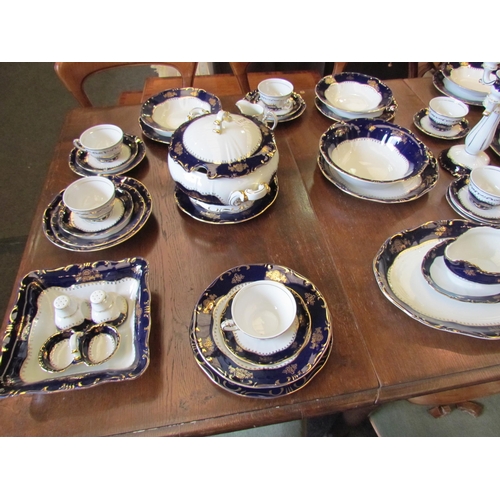 1114 - A Zsolnay, Hungary, porcelain dinner service for eight, white ground with blue and gilt border