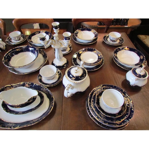 1114 - A Zsolnay, Hungary, porcelain dinner service for eight, white ground with blue and gilt border