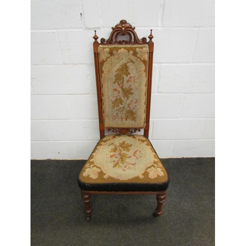 1120 - A Victorian walnut prie dieu chair, scroll-carved crest, needlepoint seat and back, on turned suppor... 