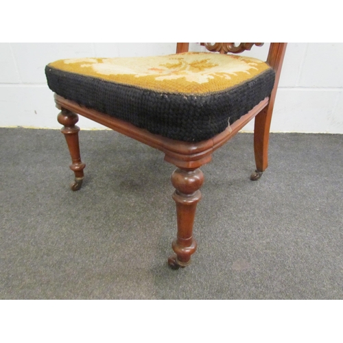 1120 - A Victorian walnut prie dieu chair, scroll-carved crest, needlepoint seat and back, on turned suppor... 