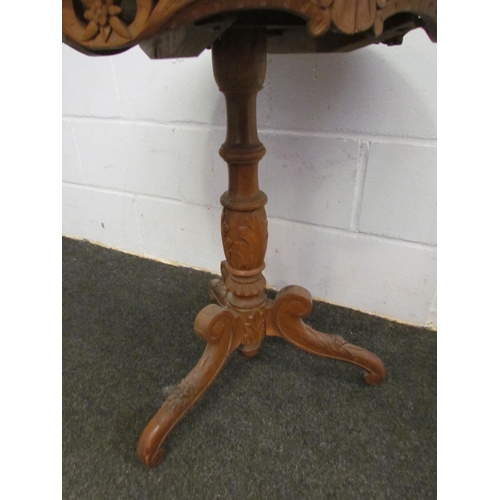 1121 - A circular top games table on carved column to tripod legs, 70cm tall x 56cm diameter