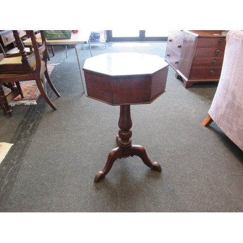 1101 - A stained oak octagonal sewing table with compartment interior on turned column supports, tri-form b... 