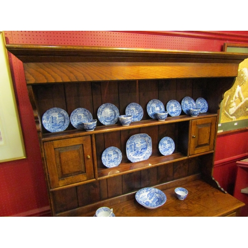 4043 - A George III style oak Welsh dresser with raised shelved back having two small cupboards over a thre... 