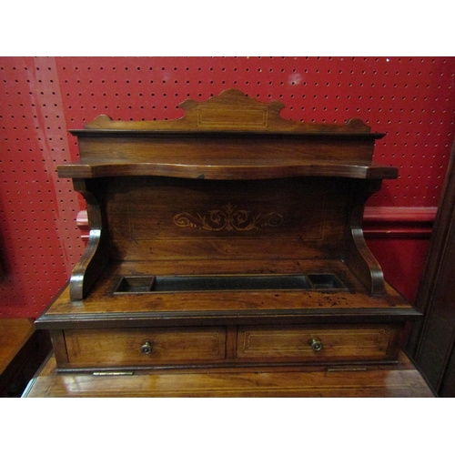 4052 - An Edwardian inlaid rosewood writing desk, the raised shelf back and two drawers over a hinged fall ... 