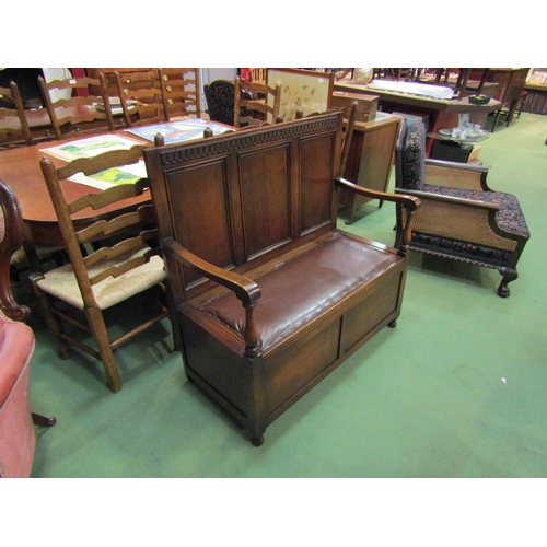 4162 - An Edwardian panelled oak box seat settle with carved decoration over a hinged seat and baluster tur... 