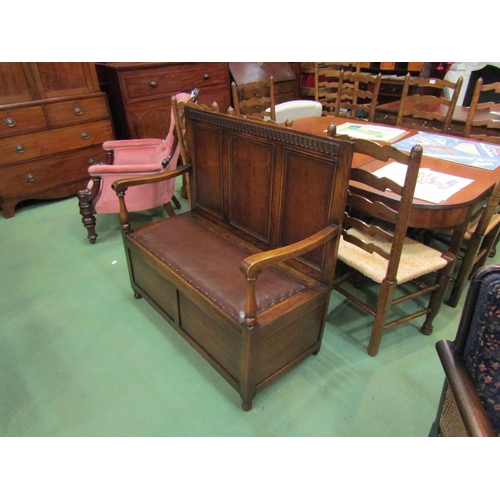 4162 - An Edwardian panelled oak box seat settle with carved decoration over a hinged seat and baluster tur... 