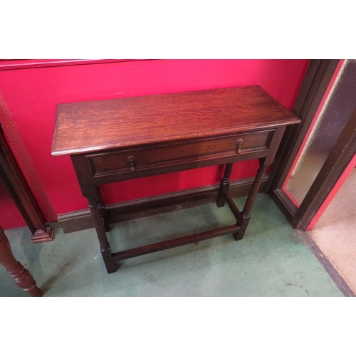 4079 - A circa 1920 oak hall table the single frieze drawer over turned cannon barrel legs united by chamfe... 