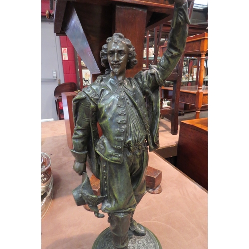 4190 - A French reproduction bronzed figural table lamp in the form of a musketeer holding a flame shade al... 