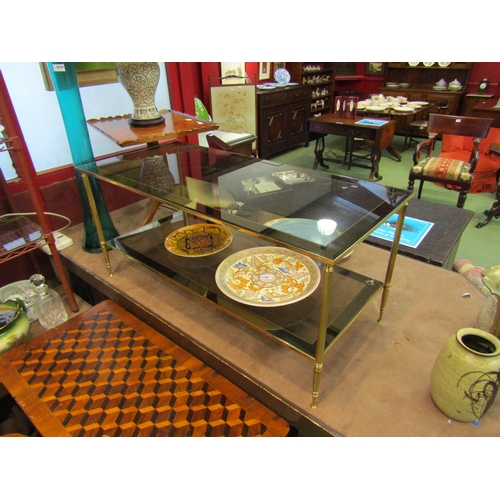 4011 - A 1970's two-tier smoked glass and brass frame occasional table with mirror borders, 46cm tall x 101... 