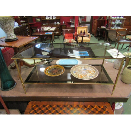 4011 - A 1970's two-tier smoked glass and brass frame occasional table with mirror borders, 46cm tall x 101... 