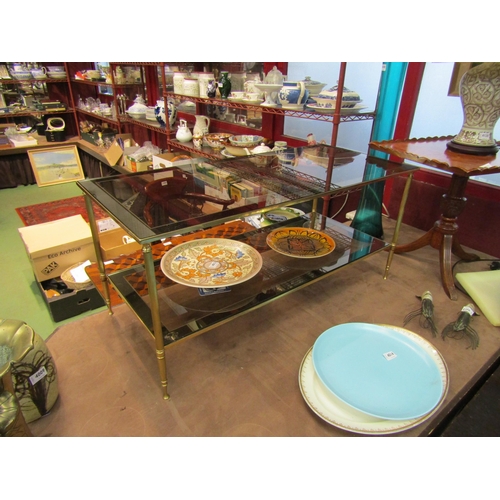 4011 - A 1970's two-tier smoked glass and brass frame occasional table with mirror borders, 46cm tall x 101... 