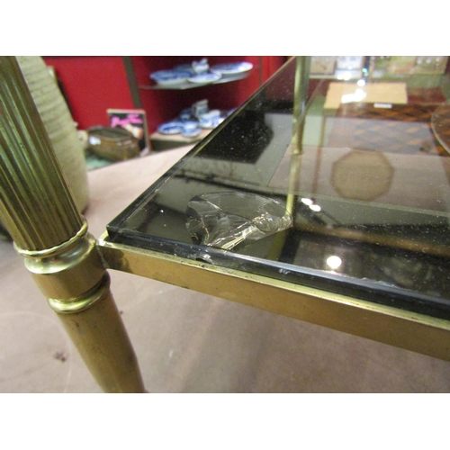 4011 - A 1970's two-tier smoked glass and brass frame occasional table with mirror borders, 46cm tall x 101... 