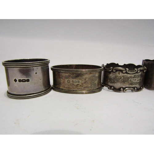 4302 - A collection of silver napkin rings, a silver stamp holder and two white metal pill holders