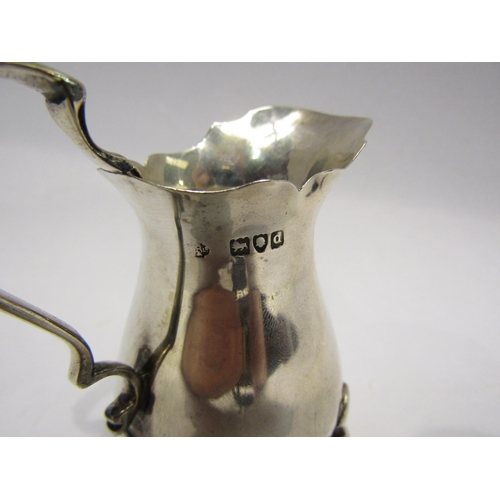 4312 - A silver cream jug on three paw feet, London 1899, William Hutton & Sons Ltd., approximately 60g