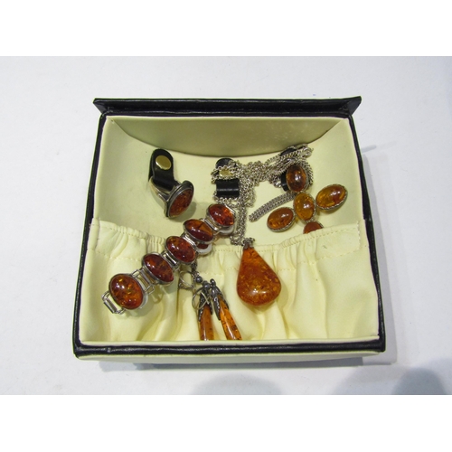 4374 - A box of amber bijouterie to include ring stamped 925, crucifix on chain stamped 925, tear drop pend... 